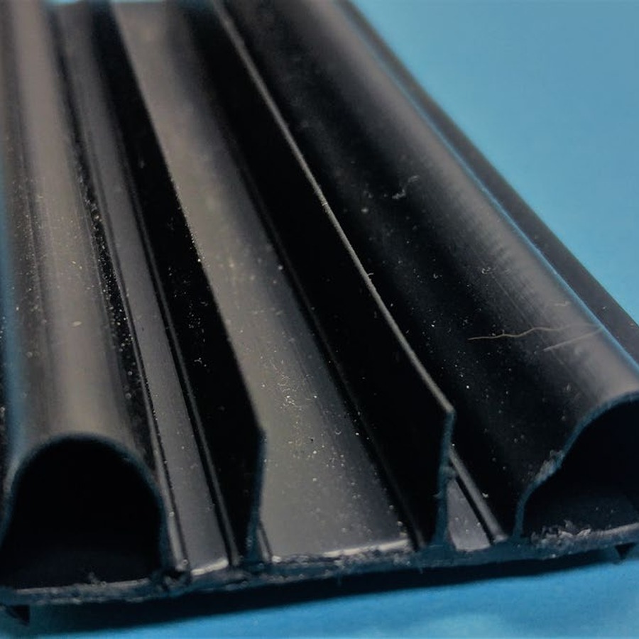 Black Alcryn door sweep profile with dual bulbs and fins on a PVC base
